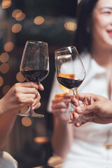Cheers to Connection: A close-up shot of two hands clinking wine glasses, capturing the intimate moment of shared celebration and connection between friends. This image evokes a sense of warmth.