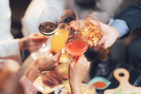 Cheers to Togetherness: A captivating overhead shot of friends raising a toast with diverse drinks, symbolizing unity and celebration during a festive gathering.  