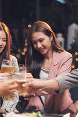 Cheers to Friendship: A group of friends raise their glasses in a toast, their smiles reflecting the warmth and camaraderie of their bond. The dim lighting creates a cozy and intimate atmosphere.