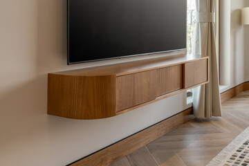 A sleek flat-screen TV mounted on the wall above a built-in decorative console. The setup creates a...