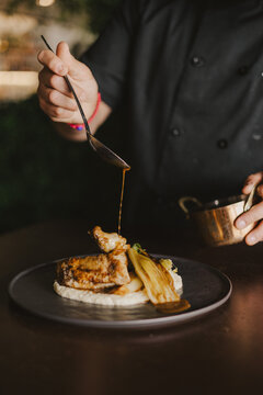 Chef Pouring Sauce on Chicken