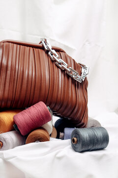 a leather bag with a handle decorated with a stack of colorful coils