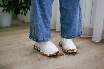 The child walks around the house in dirty shoes. Concept of child soiled laminate flooring.