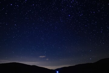 Starry Night Sky Over Silhouetted Mountains