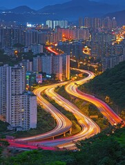 Obraz premium Elevated View of a Winding Highway at Night, Surrounded by City Buildings and Lush Greenery