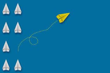 Paper plane leadership concept - yellow paper plane leading the row going in the other direction.