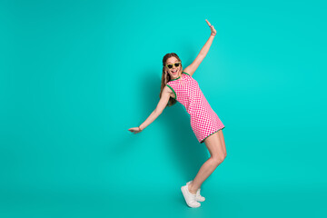 Full length photo of lovely teen lady dancing tiptoes dressed stylish pink plaid garment isolated on cyan color background