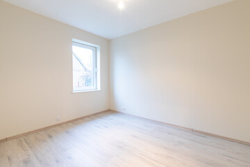 Modern New Construction Empty Room With Wooden Flooring and Large Windows Allowing Natural Light. Home Interior