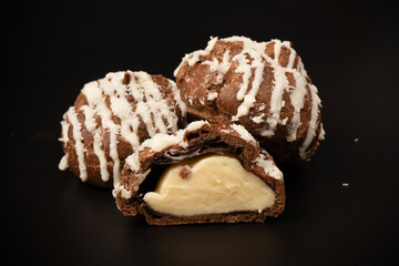 Profiteroles with coconut cream on a black background.