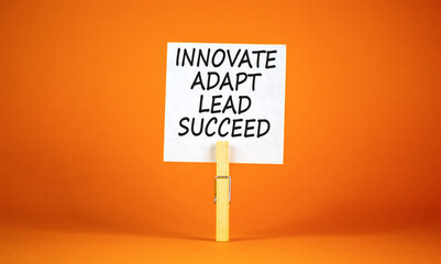 Innovate adapt lead succeed symbol. Concept words Innovate Adapt Lead Succeed on beautiful white paper. Beautiful orange background. Business innovate adapt lead succeed concept. Copy space.