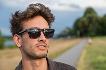 Junger Mann aus Indien steht in der Natur und posiert