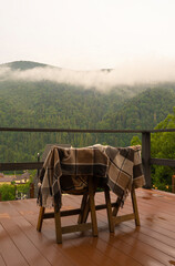 Wooden chairs with a blanket on the background of a mountain landscape, vacation in the mountains
