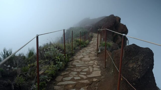 The Pico do Arieiro mountain pass, fenced with ropes and surrounded by mist. Madeira.