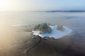 A snow-covered island in a sea covered with ice.