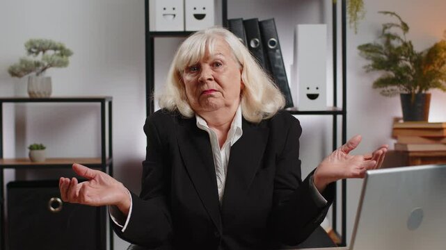 I don't know what to say. Confused senior businesswoman with laptop at home office. Freelancer feeling embarrassed about ambiguous question, having doubts, no answer idea, being clueless, uncertain.