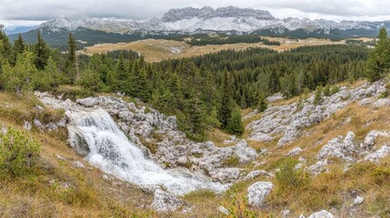 Mountain waterfall cascading down rocky terrain.
