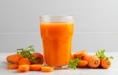 Carrot juice in a glass and fresh carrots