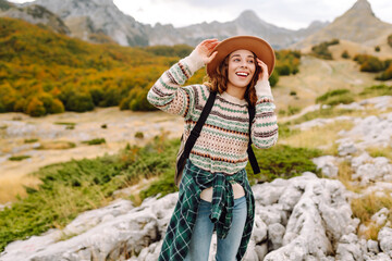 Naklejka premium A woman is walking down a path in a rocky area. The path is narrow and rocky. Travel, adventure. Concept of an active lifestyle.