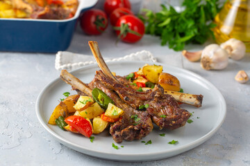 Grilled lamb chops in the oven with sautéed vegetables such as potatoes and peppers