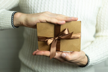 a man is holding a gift certificate with a brown satin ribbon