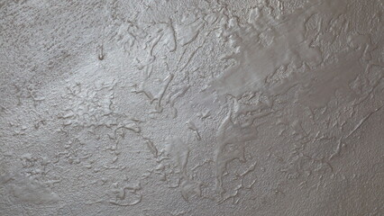 Close-up of textured grey plaster wall with intricate patterns and rough surface.