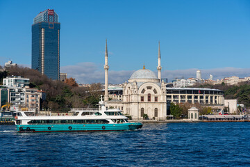 Obraz premium Dolmabahçe Mosque with the Besiktas JK Stadium on the banks of the Bosphorus in Istanbul, Turkey