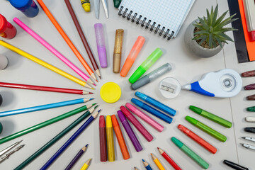 different school supplies on white desk background. Back to school concept. Flat lay composition