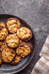 Photography of chocolate Florentines cookies with almonds and chocolate on plate on black table. Top view.