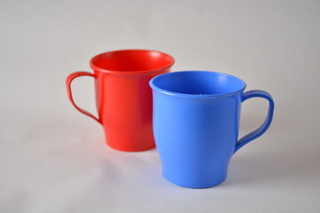 Red and blue plastic mugs displayed against a neutral background.