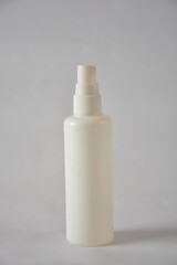 Minimalist white spray bottle against a plain background.