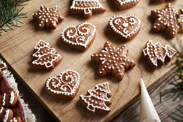 Decorating homemade gingerbread Christmas cookies with white icing