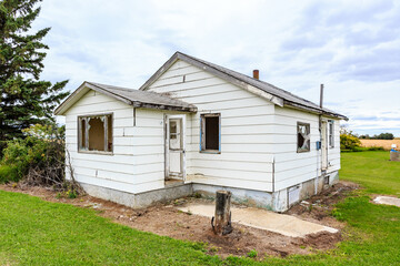 A house with a lot of broken windows and a porch