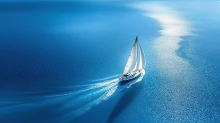 Gordijnen A white sailboat gliding gracefully across a calm, deep blue ocean with shimmering sunlight reflecting on the water © alisluch