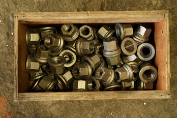 Collection of metallic fittings in a wooden box at a workshop