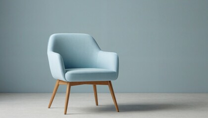 Fototapeta premium Stylish light blue armchair with smooth upholstery and wooden legs againist a matching blue background.