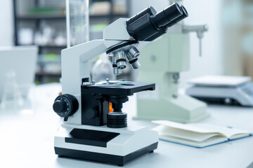 Closeup of microscope lens for analysis of biological sample in lab