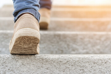 A person is walking up a set of stairs in a pair of tan shoes
