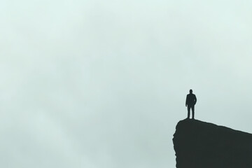 A man stands on a cliff overlooking a cloudy sky