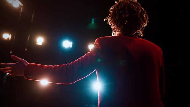 Stand-up comedy performance, joyful black man talking to microphone and smiling. Portrait of host of event or singer on stage, african american ethnicity, talented performer speaking in concert hall