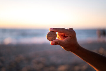 Dłoń trzymająca kamień w promieniach słońca