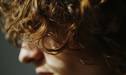 Naklejka premium Close up image of natural brown hair with curly texture, suggesting movement.