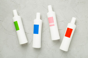 Shampoo bottles on concrete background, top view