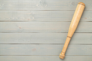 Wooden baseball bat on wooden background, top view
