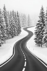 An aerial perspective of a road meandering through a forest cloaked in snow.