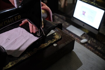 Crafting with care: hands sewing on a classic sewing machine