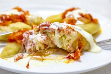 Classic Ukrainian food, perohê or veréneki stuffed with potatoes and cottage cheese and cooked, served with different types of sauce and salted and sour cream