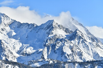 Naklejka premium French alps on a sunny day under the clouds by winter covered with snow