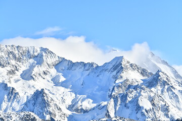 Obraz premium French alps on a sunny day under the clouds by winter covered with snow