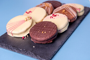 Ischler cookies coated with brown an white chocolate glaze on black