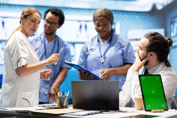 Fototapeta premium Diverse team of medics analyze x rays next to mockup copy space and discuss treatment plans in a medical office. Team of licensed healthcare specialists working to provide diagnosis on insurance.